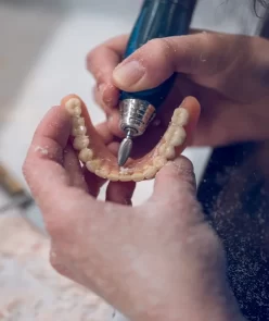 crop-person-polishing-implants-of-jaw-of-denture-2022-01-31-17-00-39-utc